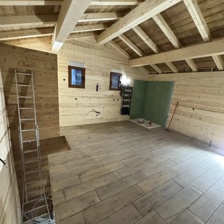 Pièce de chalet doublée en lambris clair sous charpente apparente