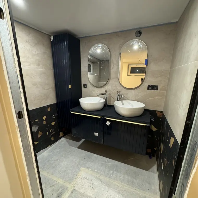 Salle de bain avec meuble double vasque bleu nuit et soubassement terrazzo
