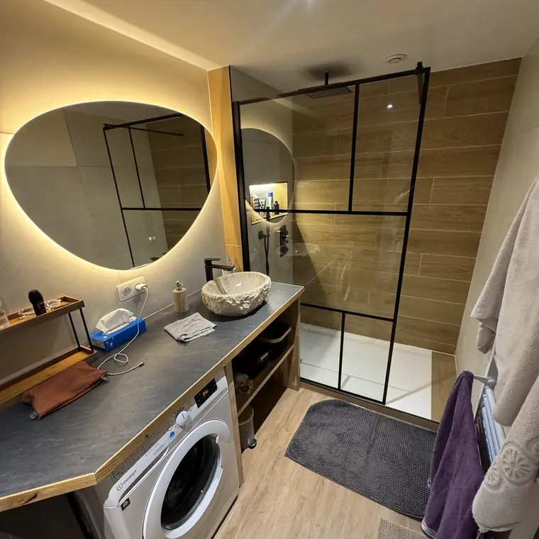 Salle de bain avec verrière d’atelier, vasque en pierre et plan béton ciré