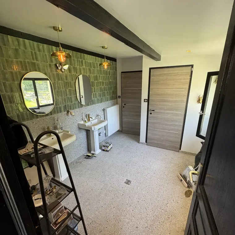 Salle de bain en zellige vert avec vasques sur pied et miroirs ronds