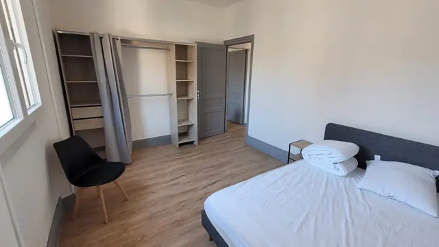 Chambre au sol imitation parquet, murs blancs, portes et plinthes peintes en gris