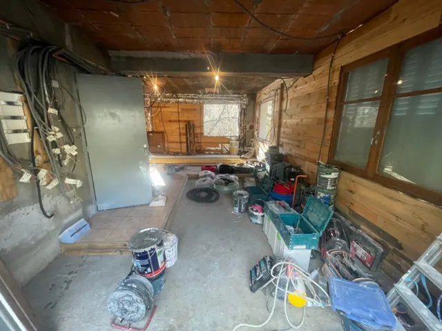 Pièce en chantier : câbles électriques en attente au mur, outillage et matériel au sol