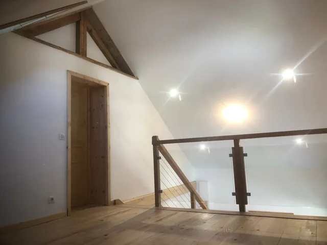 Palier de mezzanine avec garde-corps en bois et câbles, porte en bois